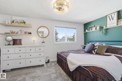 This room features a window with an exterior view, a ceiling fan with integrated lighting, and shelves for display - 29 9619 180 Street, Edmonton, AB - Indoor Photo Showing Bedroom