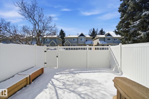 The property features a white fence enclosing a yard, with a wooden planter box visible - 29 9619 180 Street, Edmonton, AB - Outdoor