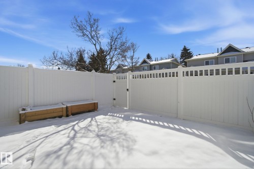 The property features a private yard with a white fence, a gate, and two raised garden beds - 29 9619 180 Street, Edmonton, AB - Outdoor