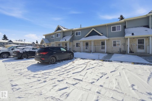 The property features a two-story exterior with light blue siding and light-colored lower-level facade, covered entryways, and white-framed windows - 29 9619 180 Street, Edmonton, AB - Outdoor