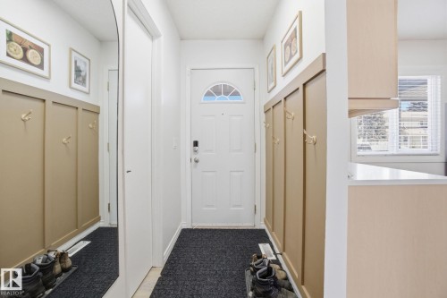 The entry features a white door with an arched window, board and batten wall detailing, and a full-length mirror - 29 9619 180 Street, Edmonton, AB - Indoor Photo Showing Other Room