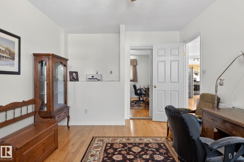 This room features hardwood floors and white walls, offering a bright and versatile space - 22 Riverpointe, Fort Saskatchewan, AB - Indoor Photo Showing Other Room