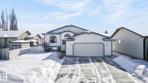 The property features a white exterior, an attached garage, and a paved driveway - 22 Riverpointe, Fort Saskatchewan, AB - Outdoor