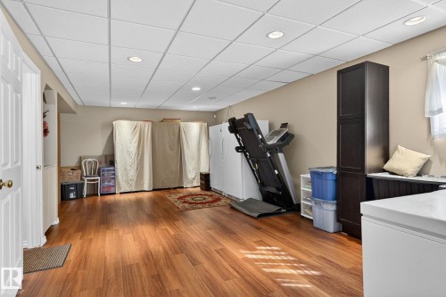 Spacious room featuring wood flooring, recessed lighting, and a drop ceiling - 22 Riverpointe, Fort Saskatchewan, AB - Indoor