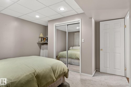 This room features light gray walls, a drop ceiling with recessed lighting, and carpeted flooring - 22 Riverpointe, Fort Saskatchewan, AB - Indoor Photo Showing Bedroom