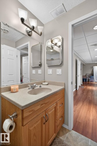 Bathroom vanity with an integrated sink, light-colored countertop, and wooden cabinetry - 22 Riverpointe, Fort Saskatchewan, AB - Indoor Photo Showing Bathroom