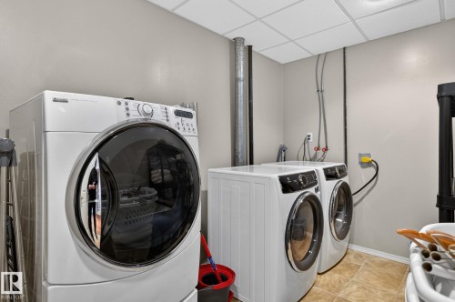 The property features a dedicated laundry area with light-colored walls and a tiled floor - 22 Riverpointe, Fort Saskatchewan, AB - Indoor Photo Showing Laundry Room