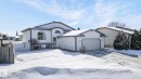 The property features a white exterior with a contrasting dark roof trim, an arched window, and an integrated garage with a driveway - 22 Riverpointe, Fort Saskatchewan, AB  - Outdoor 