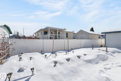 The property features a fenced yard with solar path lights, offering a defined outdoor space - 22 Riverpointe, Fort Saskatchewan, AB - Outdoor