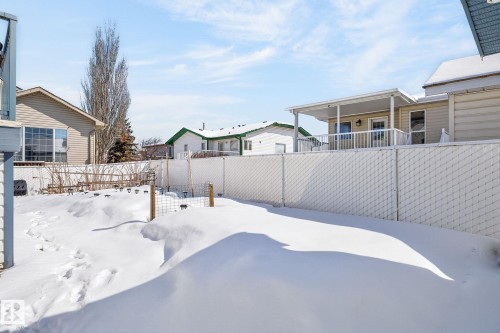 The property features a fenced yard, with a partial view of the rear exterior - 22 Riverpointe, Fort Saskatchewan, AB - Outdoor