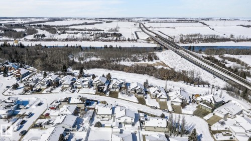 Aerial view of the neighborhood featuring a collection of residential properties with snow-covered roofs and surrounding terrain - 22 Riverpointe, Fort Saskatchewan, AB - Outdoor With View