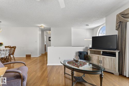 This living area features hardwood floors and a partial wall separating spaces - 22 Riverpointe, Fort Saskatchewan, AB - Indoor