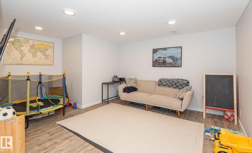 This room features light-colored walls, recessed ceiling lights, and wood-look flooring - 8326 157 Avenue, Edmonton, AB - Indoor