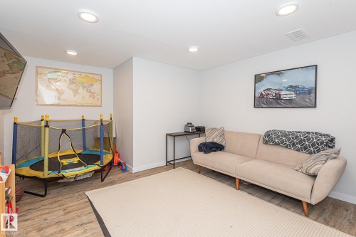 This versatile room features light-colored walls, recessed lighting, and wood-look flooring - 8326 157 Avenue, Edmonton, AB - Indoor