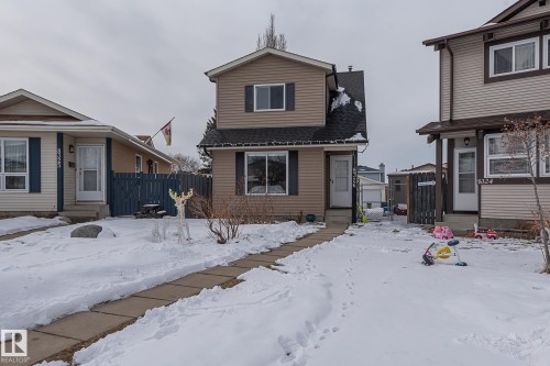 The property features a two-story exterior with horizontal siding, a dark roof, and a front entry door - 8326 157 Avenue, Edmonton, AB - Outdoor With Facade