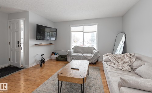Living area featuring light hardwood floors, a bright window, and light-colored walls - 8326 157 Avenue, Edmonton, AB - Indoor Photo Showing Living Room