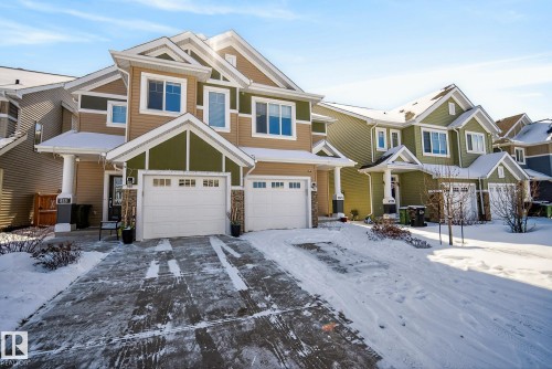 This property features a two-story exterior with a combination of tan and olive-green siding - 8225 24 Avenue, Edmonton, AB - Outdoor With Facade