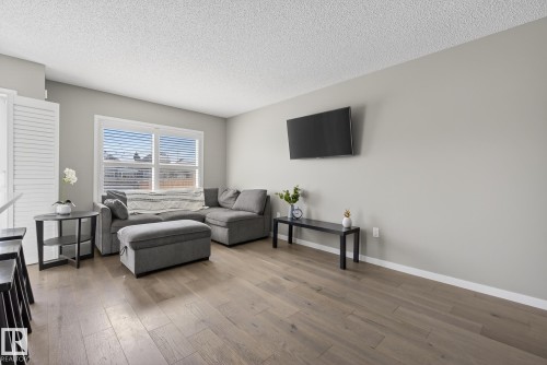 Living room featuring light-colored walls and hardwood flooring - 8225 24 Avenue, Edmonton, AB - Indoor Photo Showing Living Room