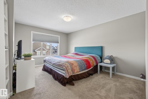 The room features neutral-toned walls and carpet, a window with a white frame, and a ceiling light fixture - 8225 24 Avenue, Edmonton, AB - Indoor Photo Showing Bedroom