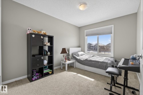 The room features light gray walls, a window with a view of other properties, and a neutral-toned carpet - 8225 24 Avenue, Edmonton, AB - Indoor Photo Showing Bedroom