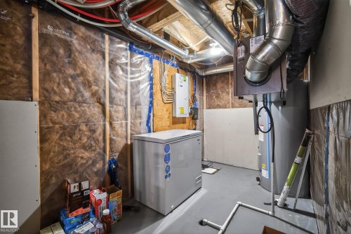 The property features an unfinished utility space with visible insulation, exposed ceiling joists, and a water heater - 8225 24 Avenue, Edmonton, AB - Indoor Photo Showing Basement