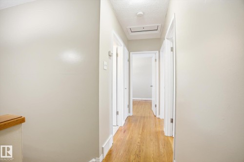 The property features a hallway with hardwood flooring and light-colored walls, complemented by white trim and doors - 6 Garden Crescent, St. Albert, AB - Indoor Photo Showing Other Room