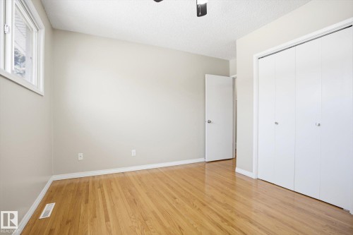 Room featuring hardwood floors, a window with white trim, and a white bi-fold closet - 6 Garden Crescent, St. Albert, AB - Indoor Photo Showing Other Room