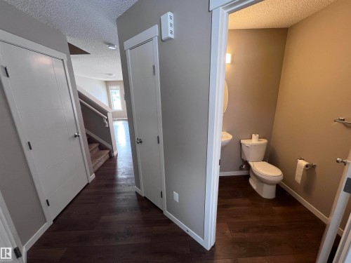 The property features dark hardwood flooring throughout the hallway and into the powder room - 1421 26 Avenue, Edmonton, AB - Indoor Photo Showing Bathroom