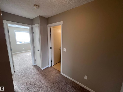 The interior features neutral wall paint and carpeting, with white trim around doorways and baseboards - 1421 26 Avenue, Edmonton, AB - Indoor Photo Showing Other Room