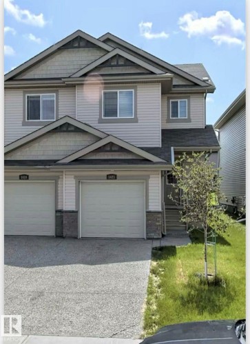 The property features a two-story exterior with light-colored siding and dark trim accents - 1421 26 Avenue, Edmonton, AB - Outdoor