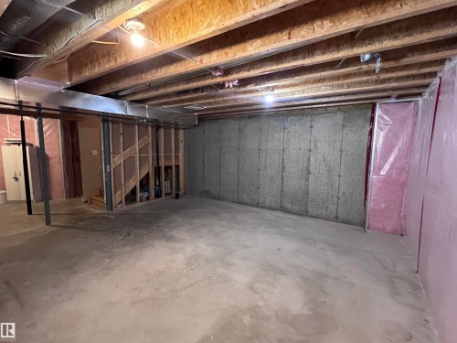 The unfinished space features concrete walls and flooring, with visible ceiling joists and insulation - 1421 26 Avenue, Edmonton, AB - Indoor Photo Showing Basement