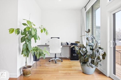 This room features hardwood floors and large windows, providing ample natural light - 9821 85 Avenue, Edmonton, AB - Indoor Photo Showing Other Room