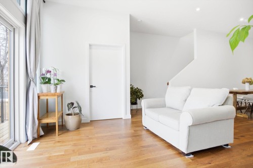 The living area features hardwood floors and a sliding glass door leading to an outdoor deck - 9821 85 Avenue, Edmonton, AB - Indoor Photo Showing Living Room