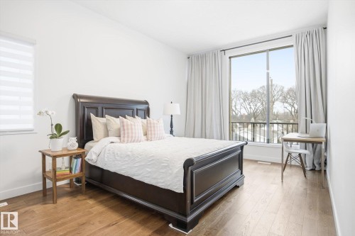 The property features a spacious room with hardwood floors and bright white walls - 9821 85 Avenue, Edmonton, AB - Indoor Photo Showing Bedroom