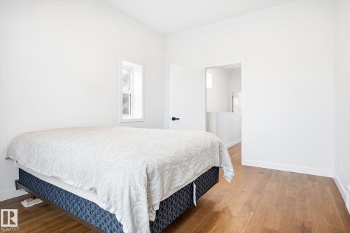 This room features hardwood flooring, white walls, and a window providing natural light - 9821 85 Avenue, Edmonton, AB - Indoor Photo Showing Bedroom