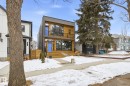 The property features a contemporary exterior with wood siding and large windows, complemented by a vibrant blue front door and a matching blue balcony door - 9821 85 Avenue, Edmonton, AB  - Outdoor With Facade 