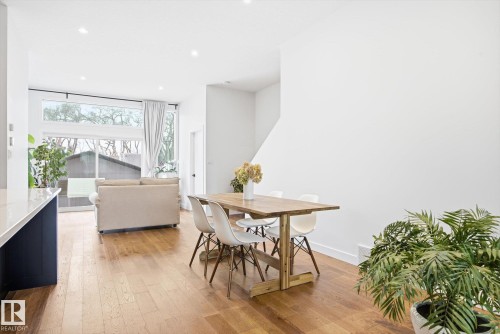 Open-concept living area featuring hardwood flooring, recessed lighting, and large windows - 9821 85 Avenue, Edmonton, AB - Indoor