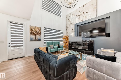 This living area features a high vaulted ceiling, light wood flooring, and large windows with blinds - 15108 11 Street, Edmonton, AB - Indoor Photo Showing Living Room