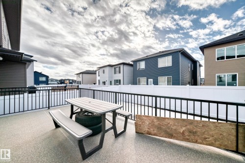 The property features an outdoor patio area with a black metal railing and a white privacy fence - 15108 11 Street, Edmonton, AB - Outdoor With Exterior