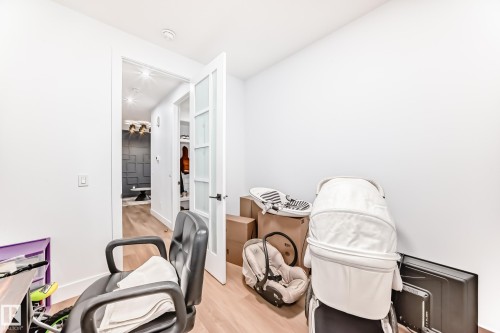 This room features light-toned hardwood flooring and a white door with frosted glass panels - 15108 11 Street, Edmonton, AB - Indoor