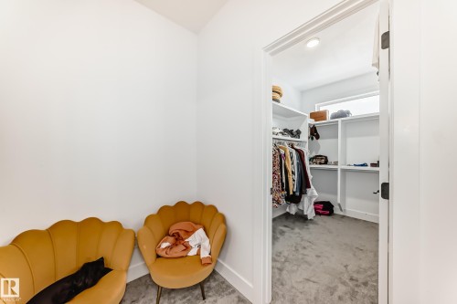 The property includes a walk-in closet with built-in shelving, clothing racks, and a window for natural light - 15108 11 Street, Edmonton, AB - Indoor