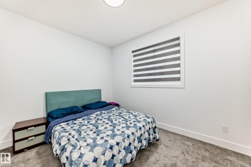 Well-lit room with white walls, a ceiling light fixture, and a window featuring horizontal blinds - 15108 11 Street, Edmonton, AB - Indoor Photo Showing Bedroom