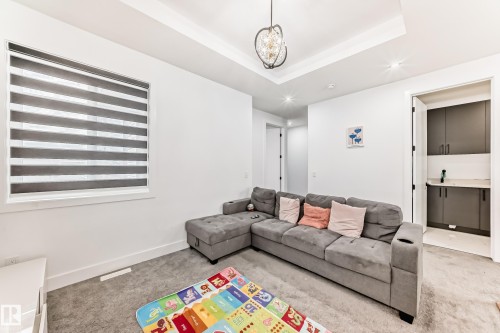 This room features white walls, carpeted flooring, and a decorative light fixture - 15108 11 Street, Edmonton, AB - Indoor Photo Showing Other Room