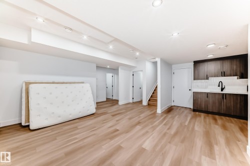 This expansive room features light wood flooring, white walls, and recessed lighting - 15108 11 Street, Edmonton, AB - Indoor