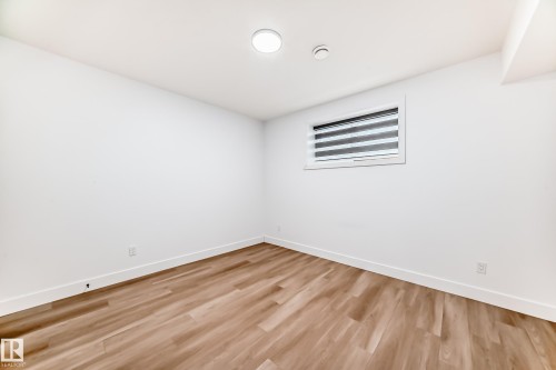 This room features light wood-style flooring, white walls, and a window with blinds - 15108 11 Street, Edmonton, AB - Indoor Photo Showing Other Room