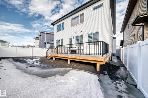 The property features a white exterior, a rear deck with black railings, and a white privacy fence enclosing the yard - 15108 11 Street, Edmonton, AB - Outdoor With Exterior