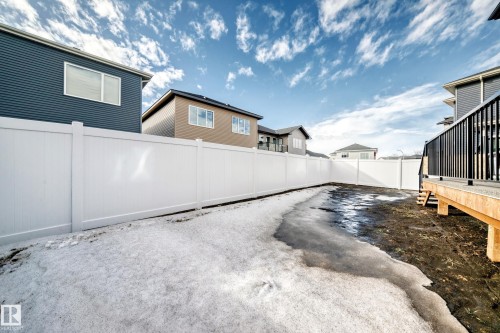The property features a white privacy fence enclosing a yard space, with a deck visible on one side - 15108 11 Street, Edmonton, AB - Outdoor