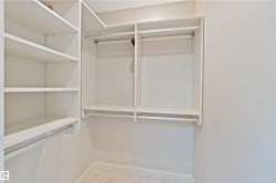 Closet with built-in shelving, hanging rods, and light-colored walls - 