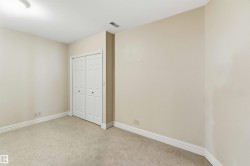 This room features neutral-toned carpet flooring, light-colored walls, white baseboards, and a white bi-fold closet door - 