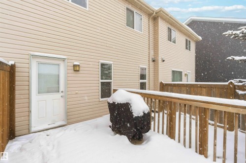 The property features a private fenced patio area with a wooden deck, accessible via an exterior door - 1313 Chappelle Boulevard, Edmonton, AB - Outdoor With Exterior